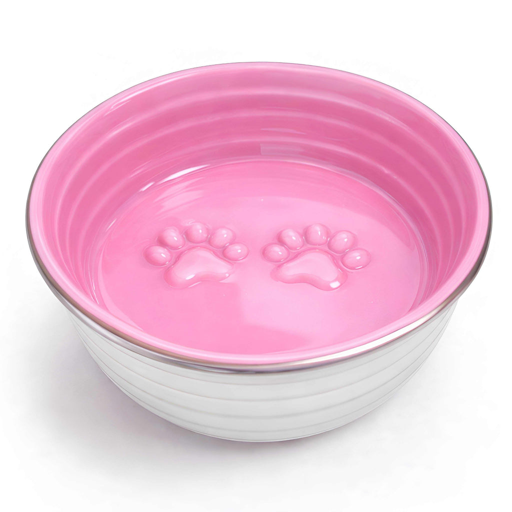 The Poppy Collection Dog Bowl in pink with stainless steel exterior, glossy interior, and raised paw print design inside.